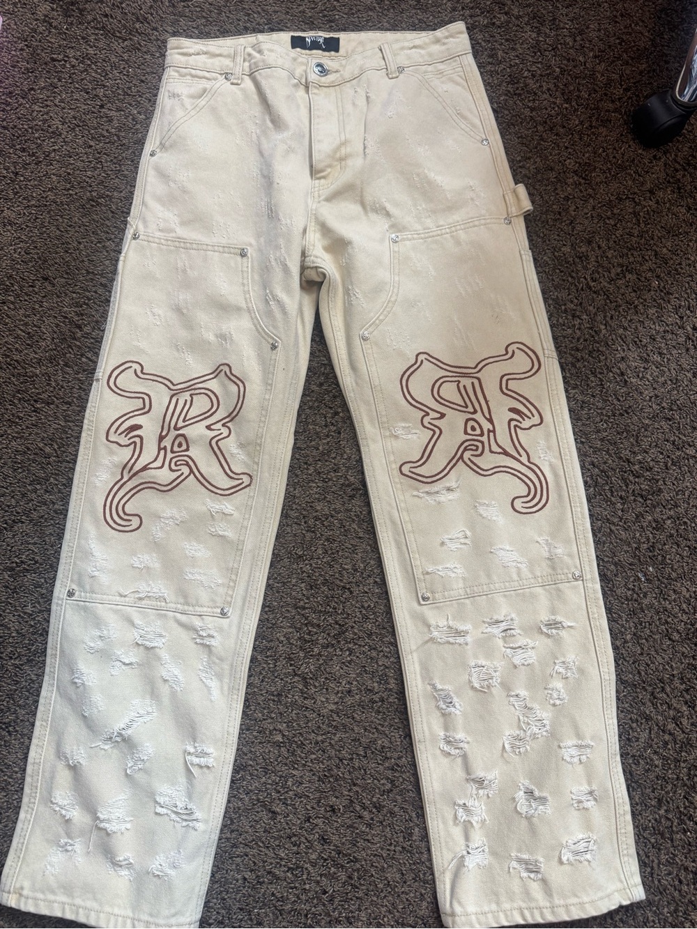 Revenge Clothing Cream Distressed Jeans with red/Burgundy Embroidered Knee Logos